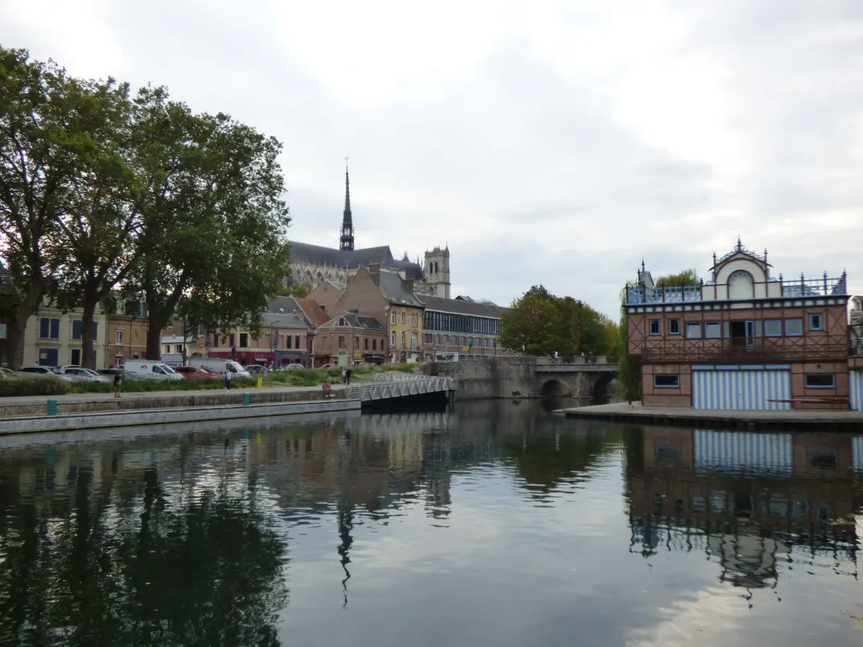 Arm of the river reflecting the rooftops and a bridge in the town centre