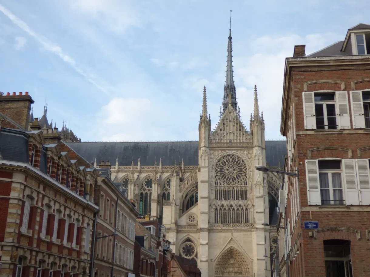 Side of the cathedral and its rose window seen from a brick street
