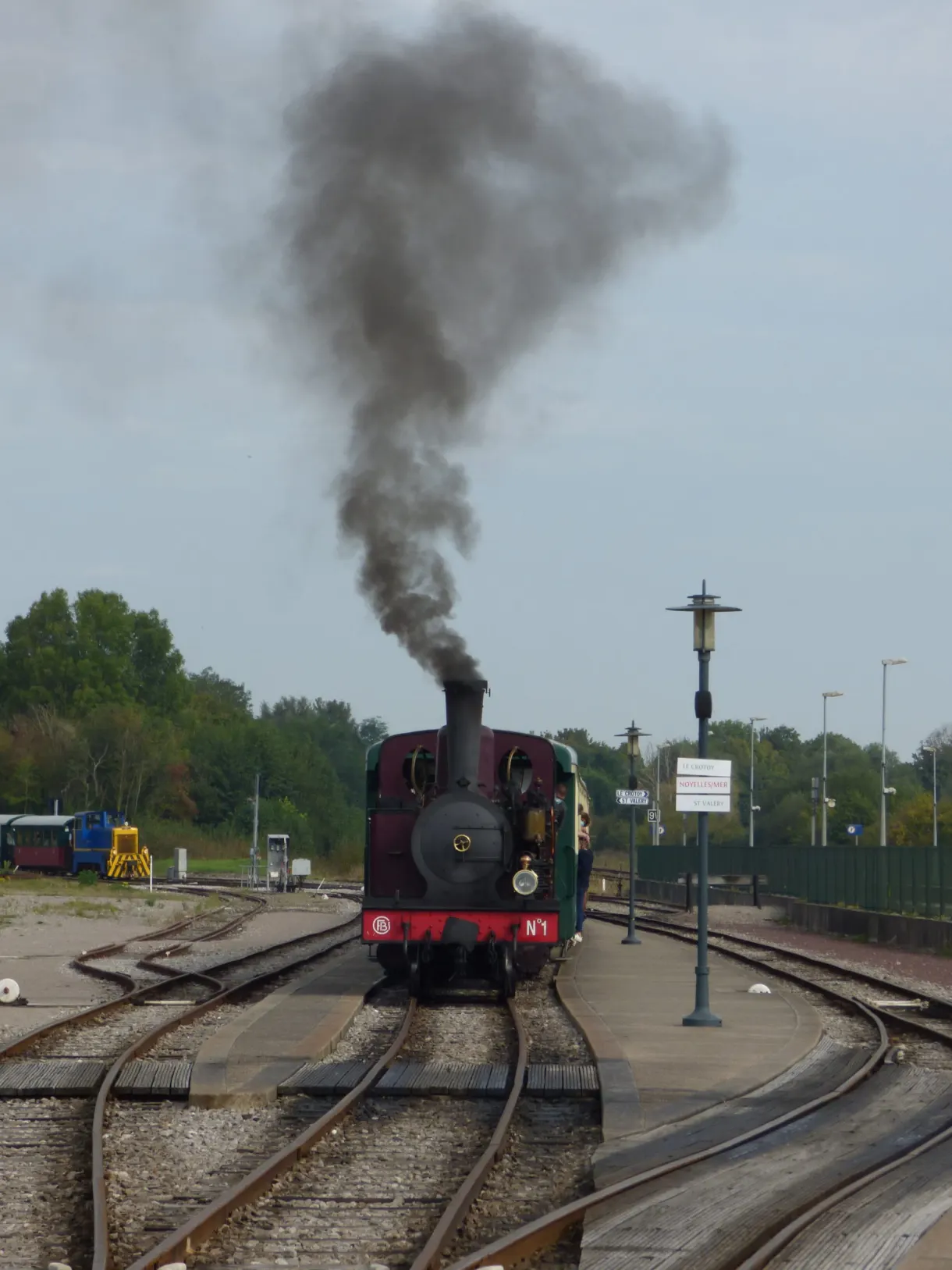 Column of black smoke above the locomotive in the station