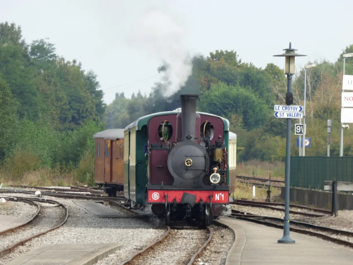 Green and red steam locomotive shunting on the tracks