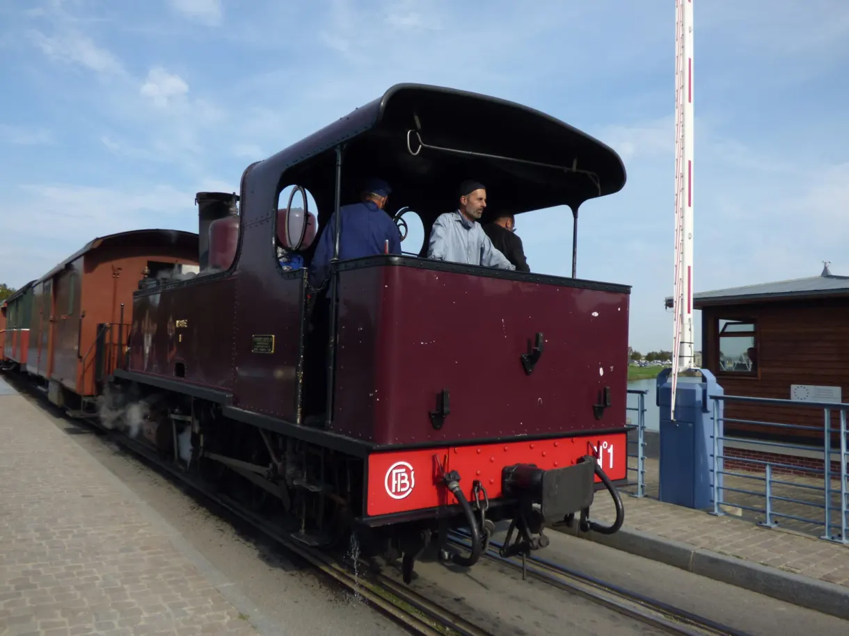 Enginemen aboard the burgundy locomotive at the level crossing