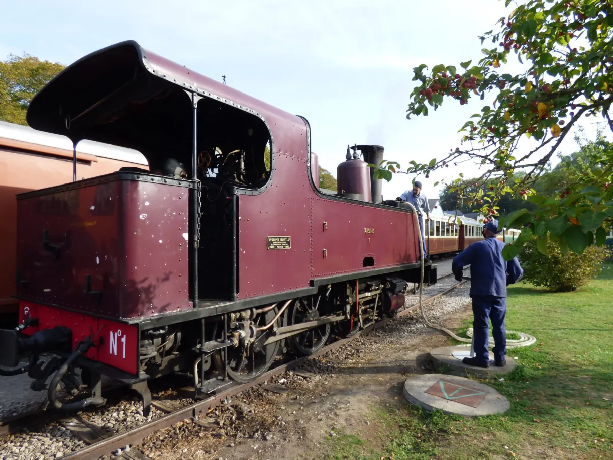Burgundy locomotive number 1 standing along the platform