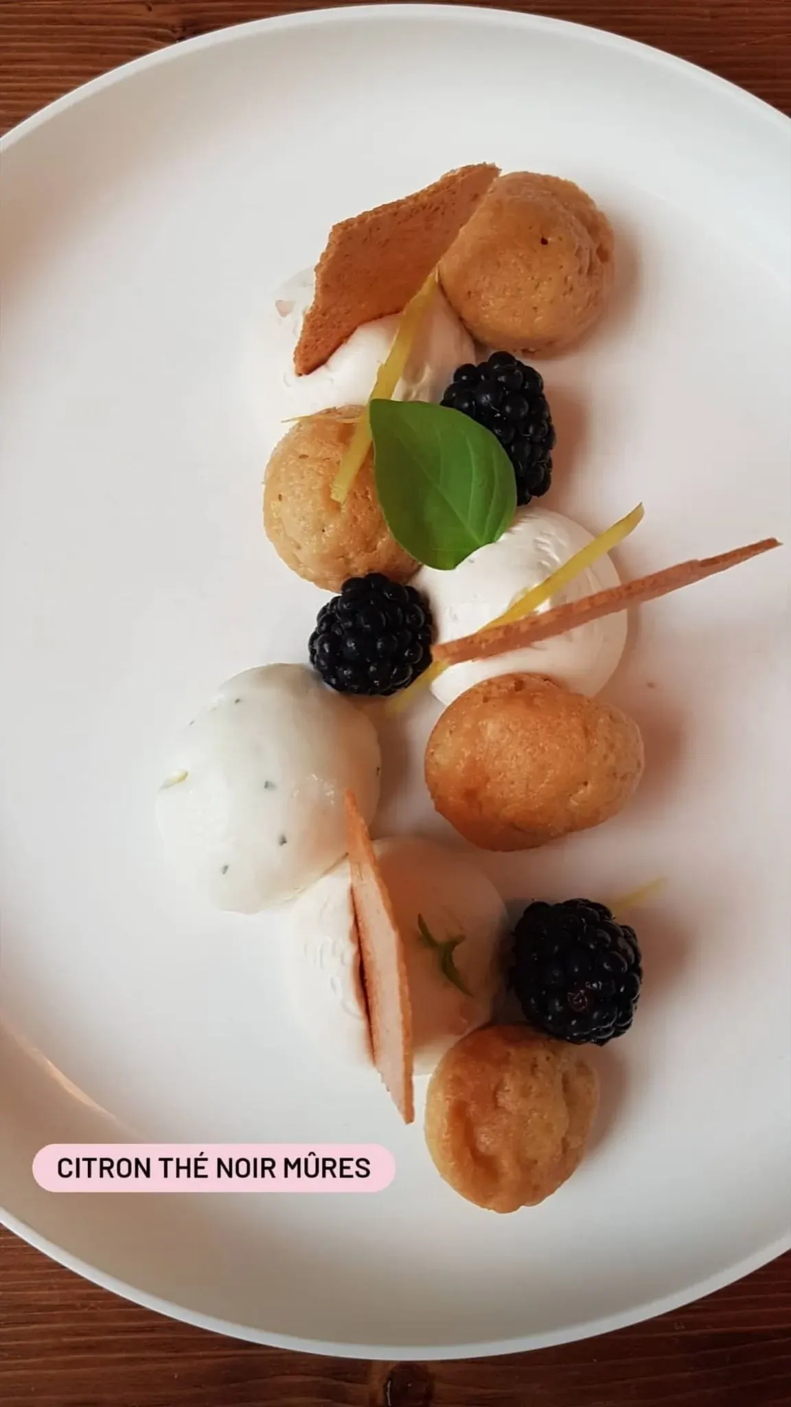 Lemon, black tea and blackberry dessert plated on white
