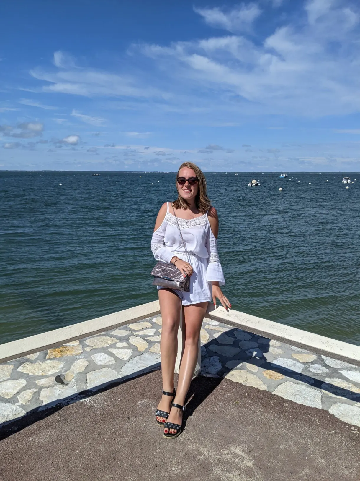 On the sea wall facing the basin, sailing boats at anchor