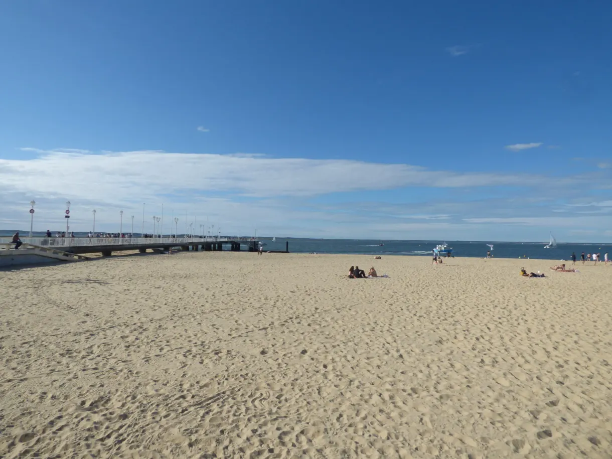 Long sandy beach and jetty under a hazy sky