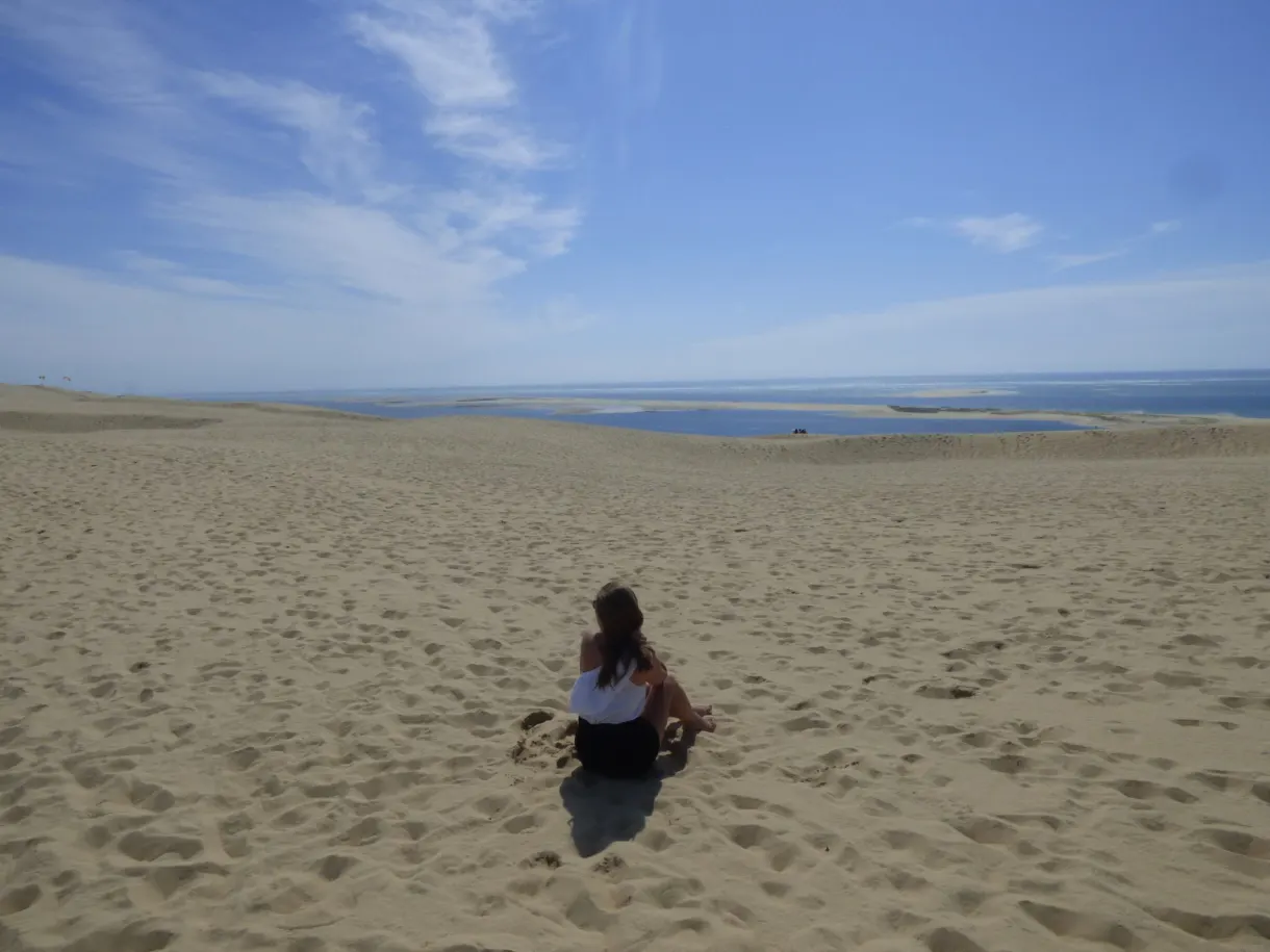 Sitting in the sand facing the basin and the horizon