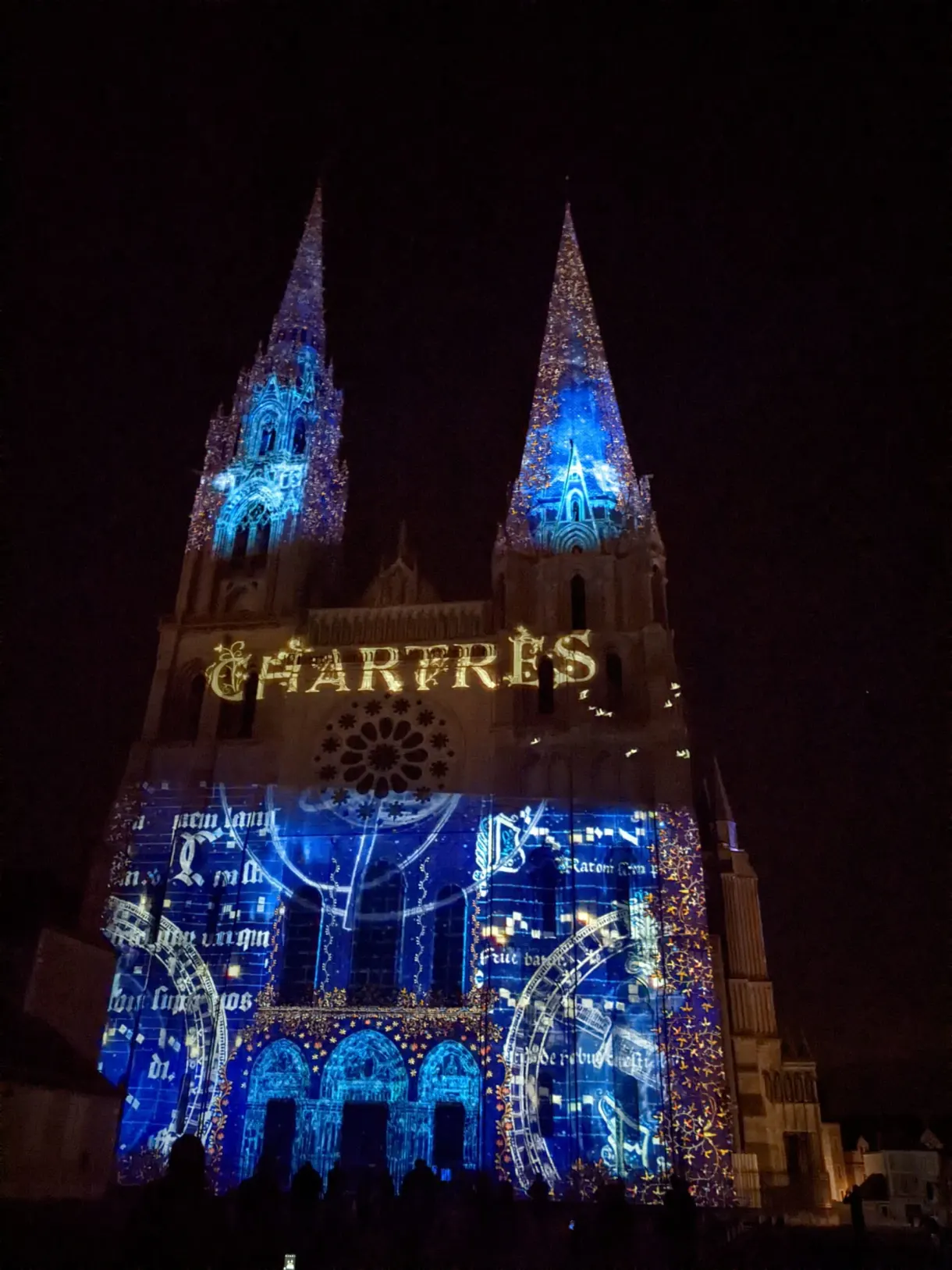 Cathédrale illuminée de bleu portant le nom de Chartres projeté