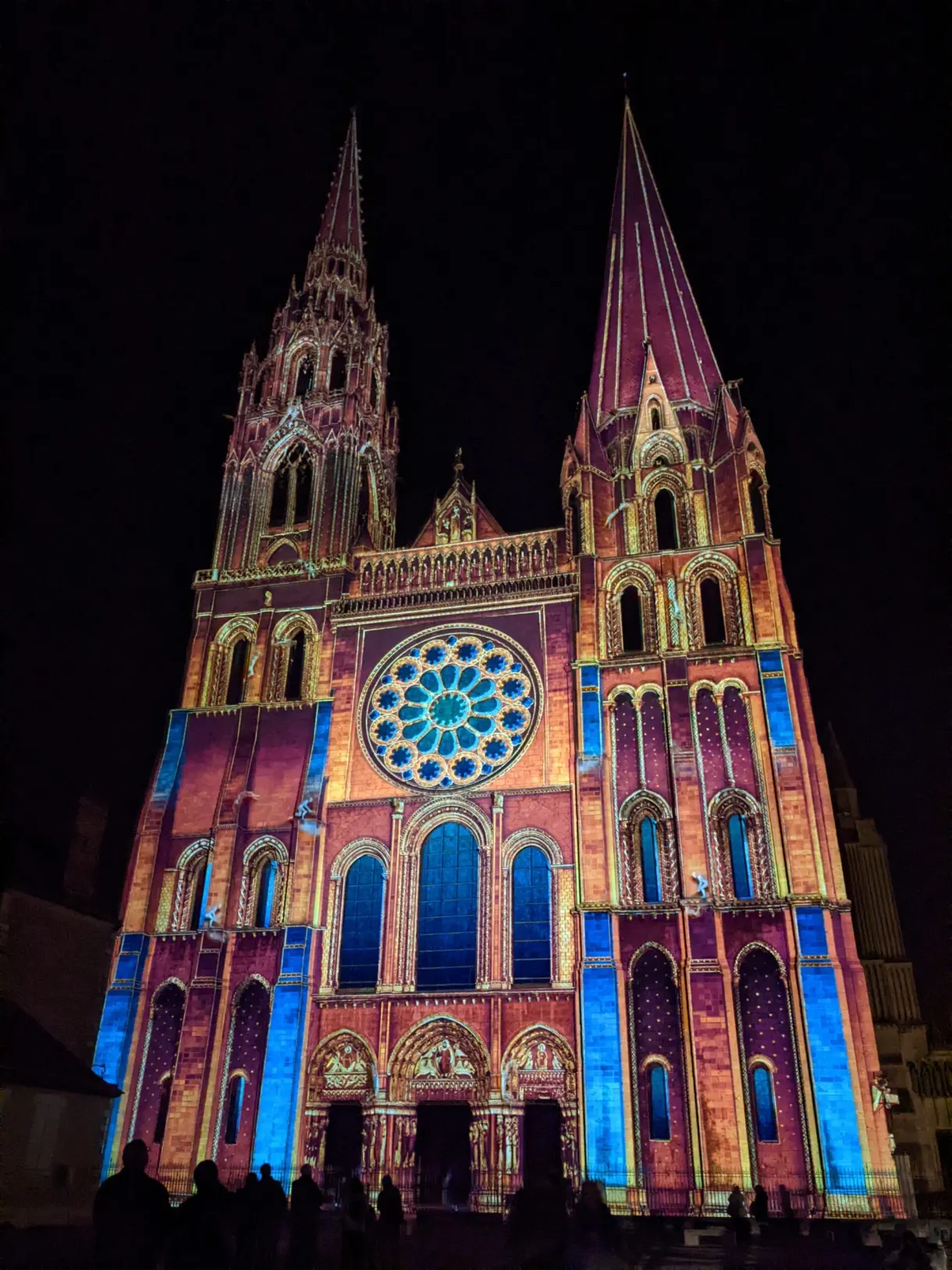 Façade de la cathédrale peinte de rose et d'or par les projecteurs