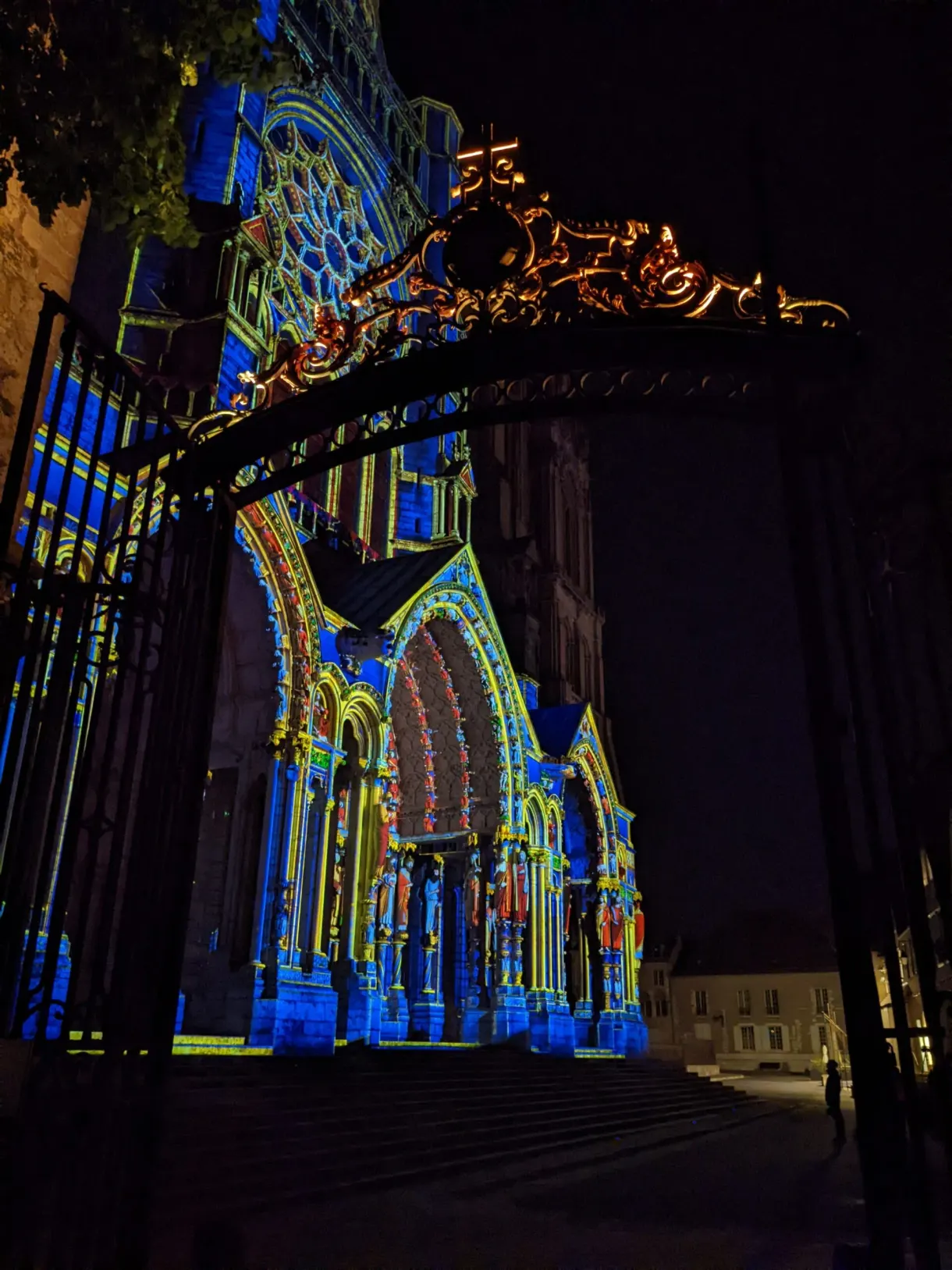 Motifs de vitrail projetés en bleu sur une façade la nuit