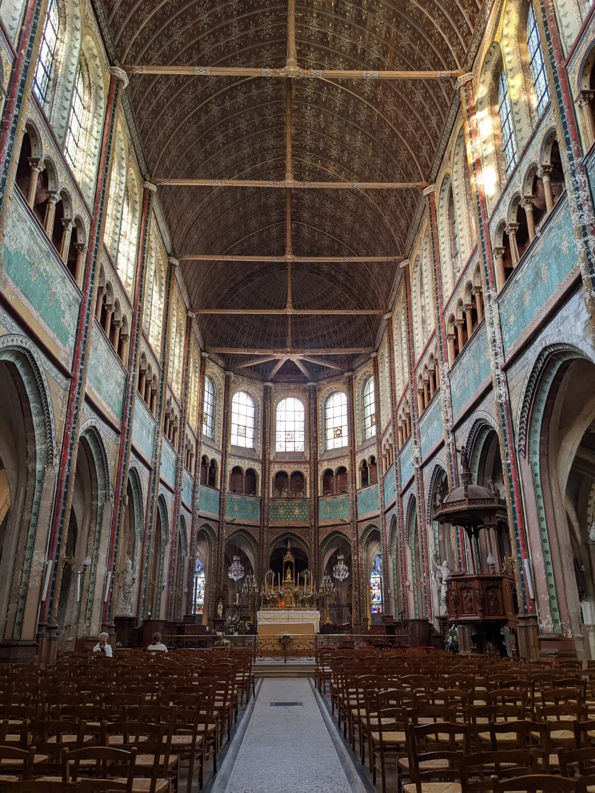 Nef lambrissée d'une église et ses rangées de chaises