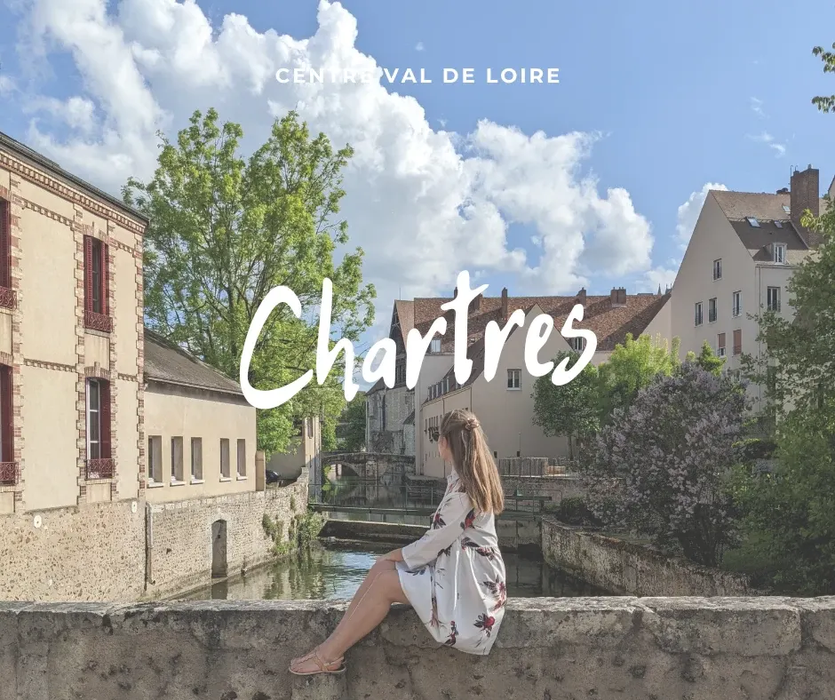 Voyageuse assise sur un muret face aux maisons du bord de l'Eure
