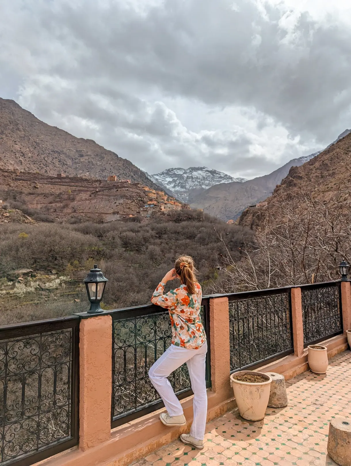 Marie on the terrace of the Kasbah du Toubkal, facing the snow-capped peaks of the High Atlas